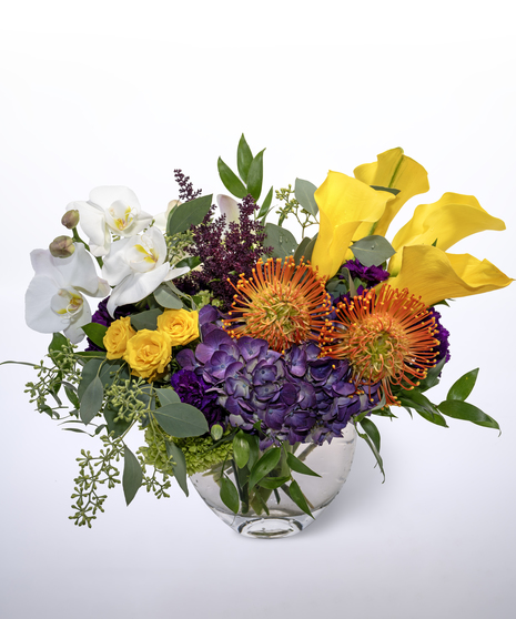 blue hydrangea, white phalaenopsis orchids, yellow calla lilies, purple astilbe and yellow spray roses, accented by seeded eucalyptus and italian ruscus greenery